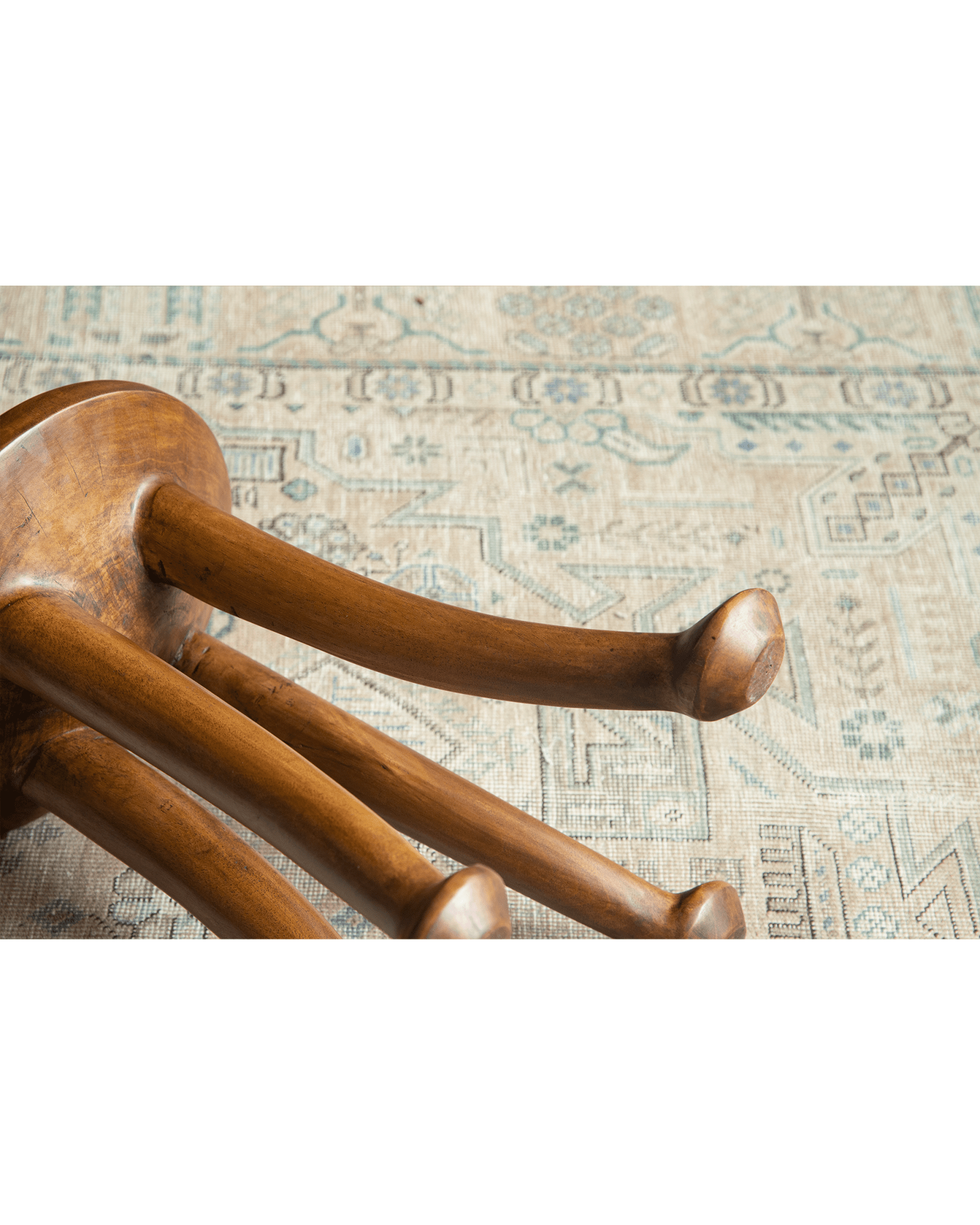 Sploot Stool underside close-up, showing three legs made of Samanea saman wood, natural finish