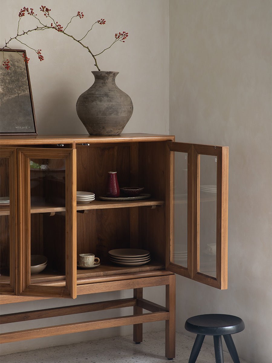 Teak wood stilt cabinet with glass doors, displaying tableware, elegant dining room storage