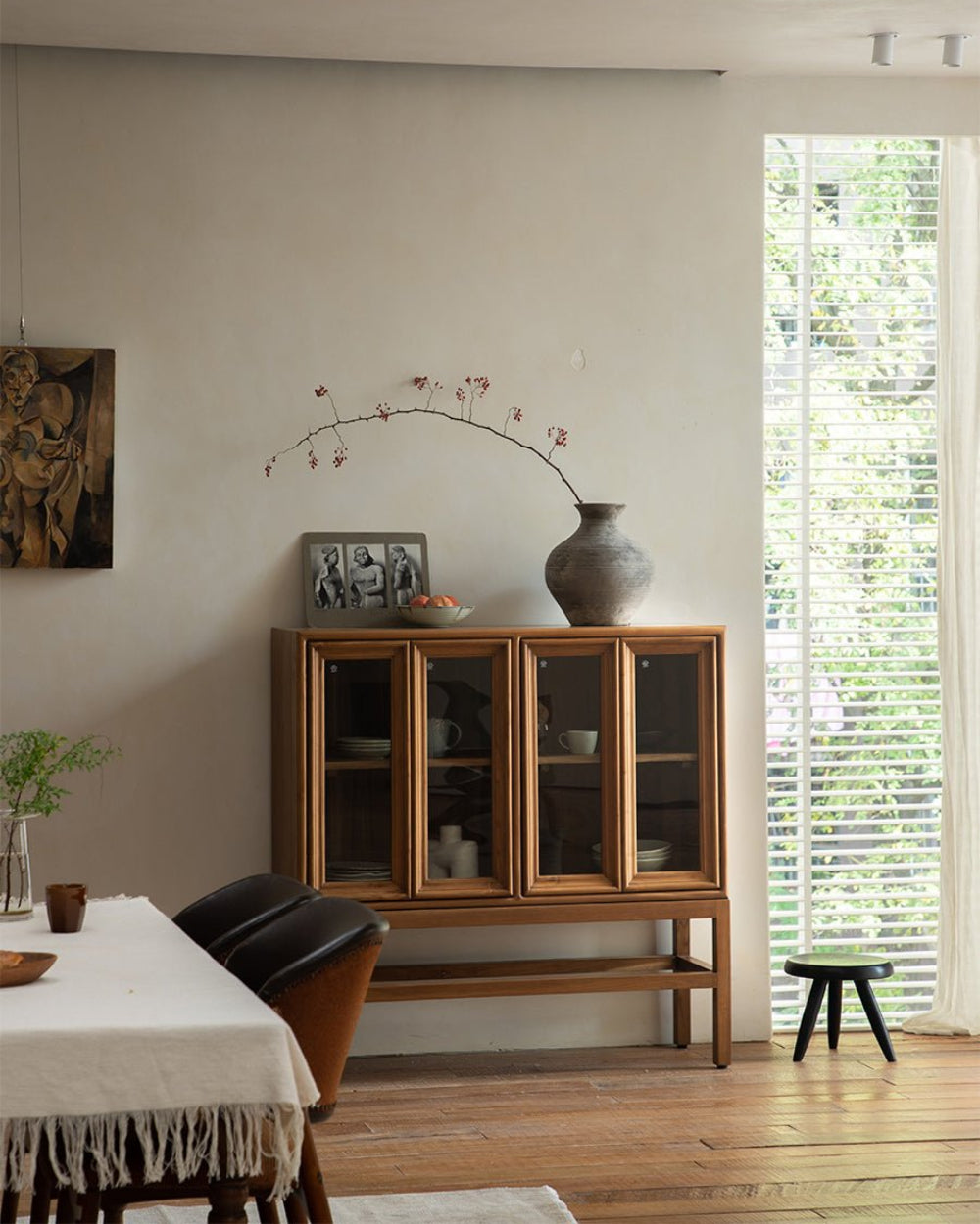 Stilt cabinet in teak wood with four glass doors for display and storage.