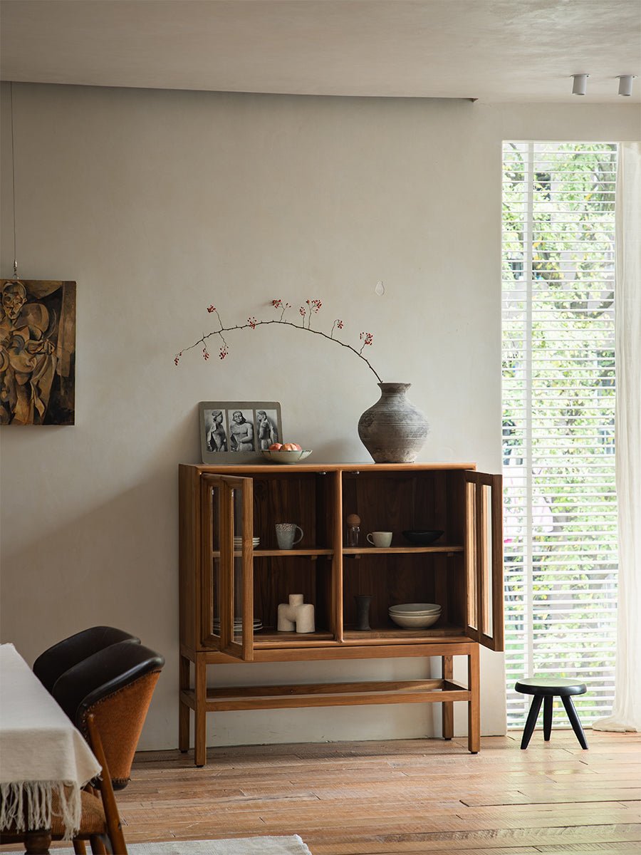 Teak wood Stilt Cabinet with glass doors in dining room, elegant display and storage solution.
