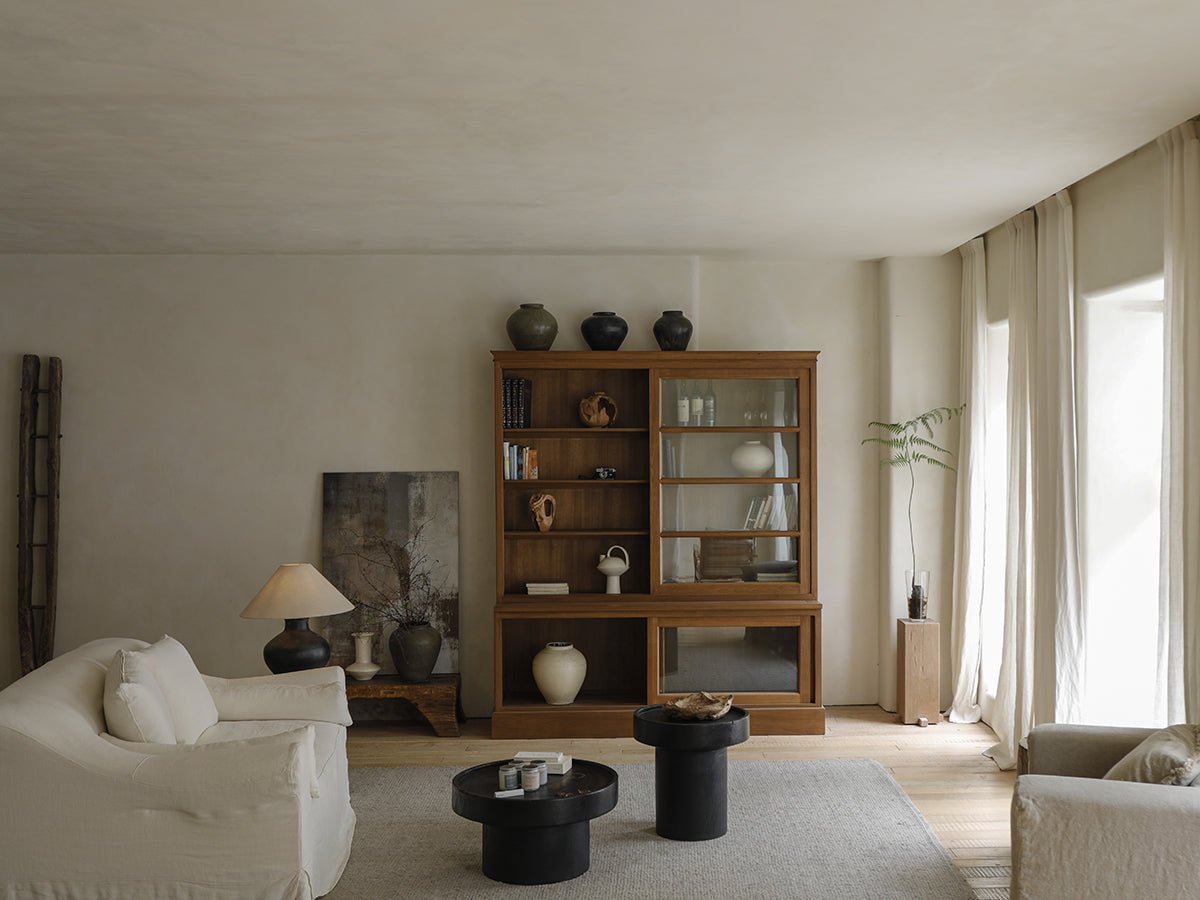 Elegant African teak glass bookcase in a living room setting with display of books and decor. Versatile storage solution.