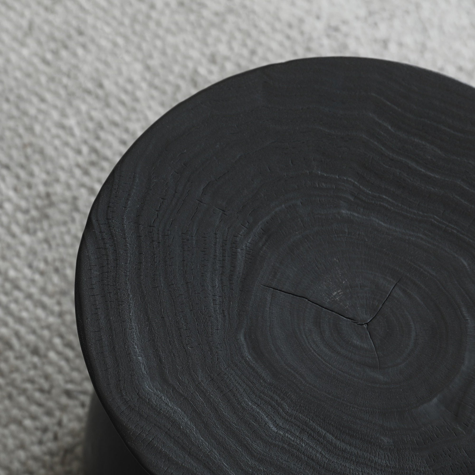 Black Sandglass table made of Samanea saman wood, showing wood grain detail, minimalist decor