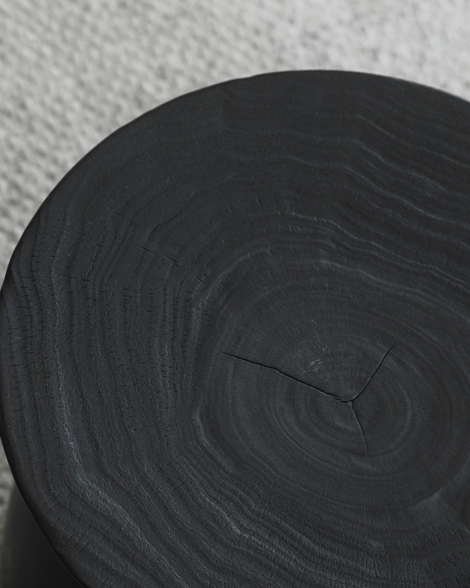 Black Sandglass table made of Samanea saman wood, showing wood grain detail, minimalist decor