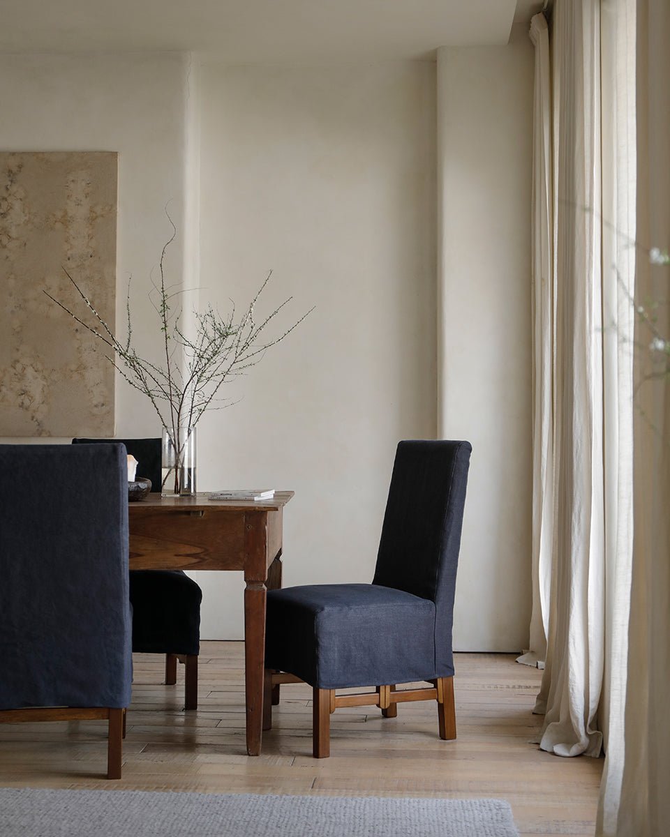 Feast Dining Chair with dark blue linen slipcover in modern dining room setting