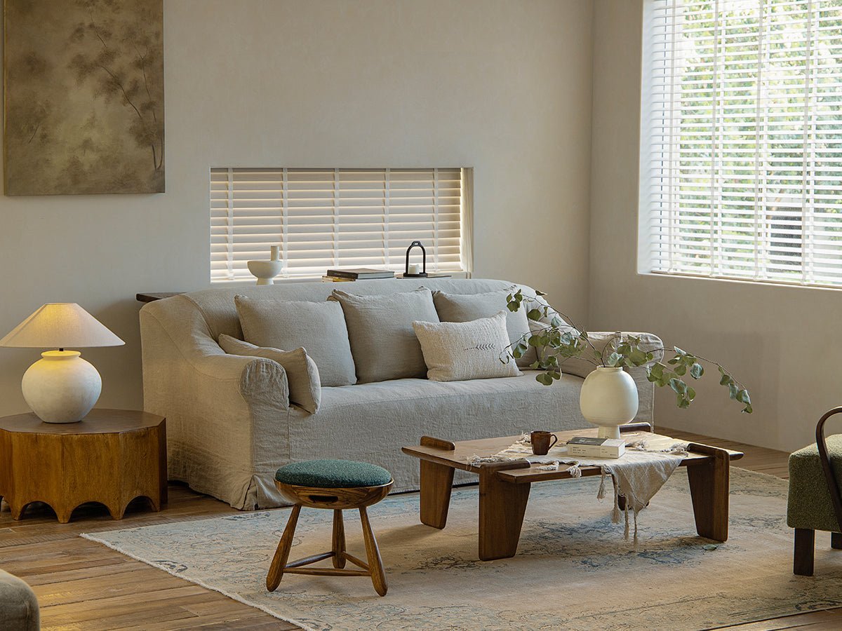Zebrawood Mocho stool in a modern living room. Featuring the stool, sofa, lamp, and wooden coffee table.