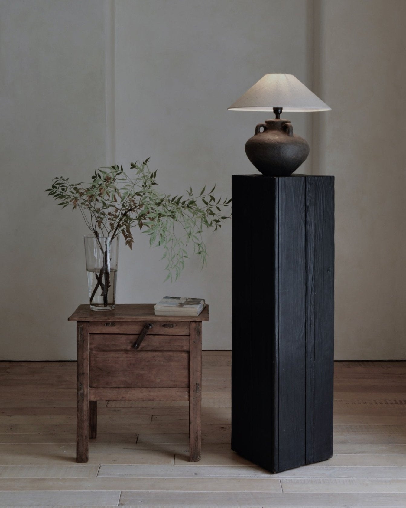 Ear Lamp with clay base and white shade on black wooden pedestal, home decor