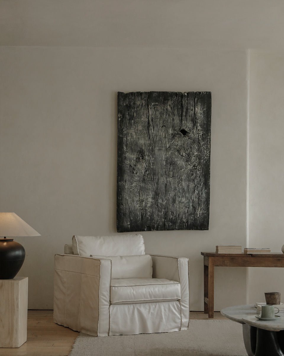 Cream skirt leather armchair in a modern living room with artwork, highlighting the elegant skirt design