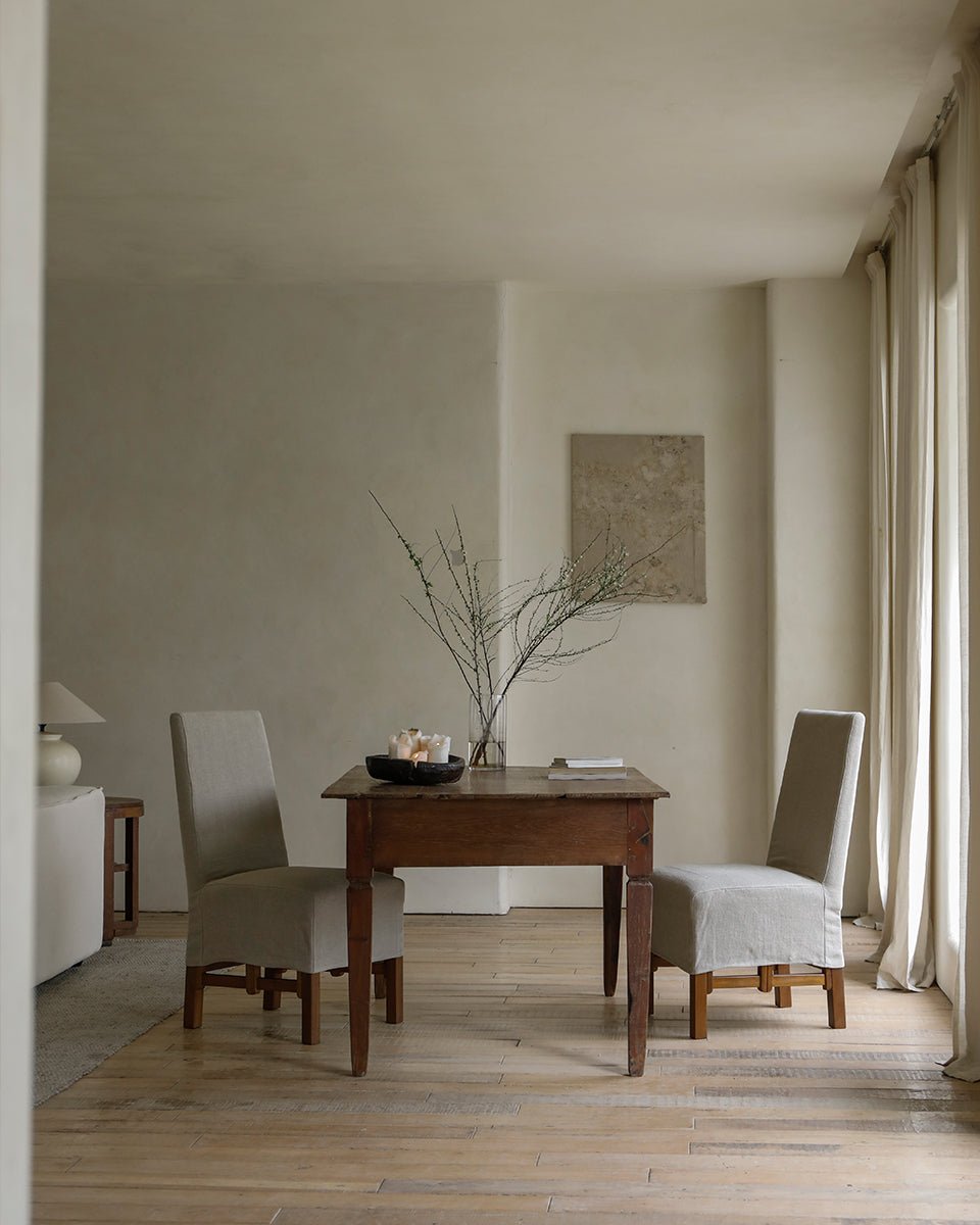 Feast Dining Chair in modern dining room, linen slipcover, wood frame, neutral tones.