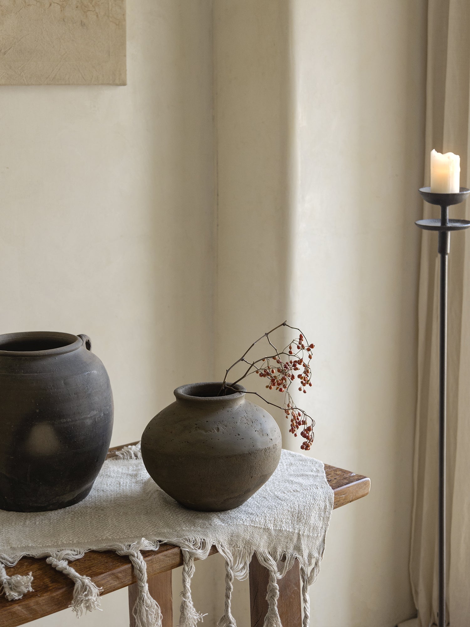 Clay pots, home decor. Vintage clay pots with a neutral color palette on a wooden table with candle light.