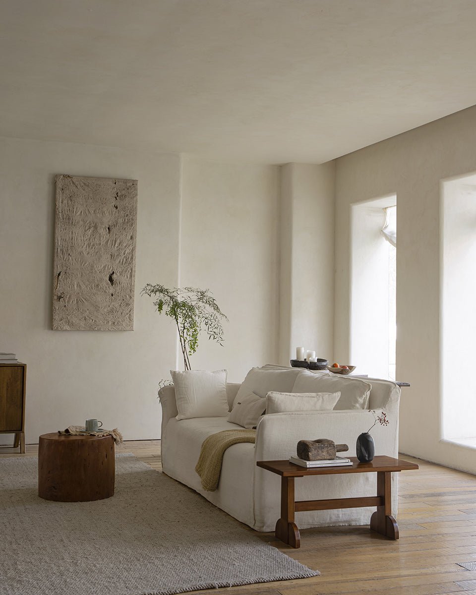 Retro living room setting with Hoof Side Table, nanmu wood, and horseshoe design alongside sofa and decor.