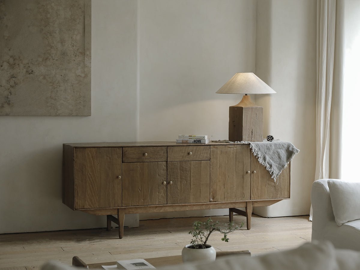 Wooden sideboard with table lamp and HOME book, cozy living room aesthetic