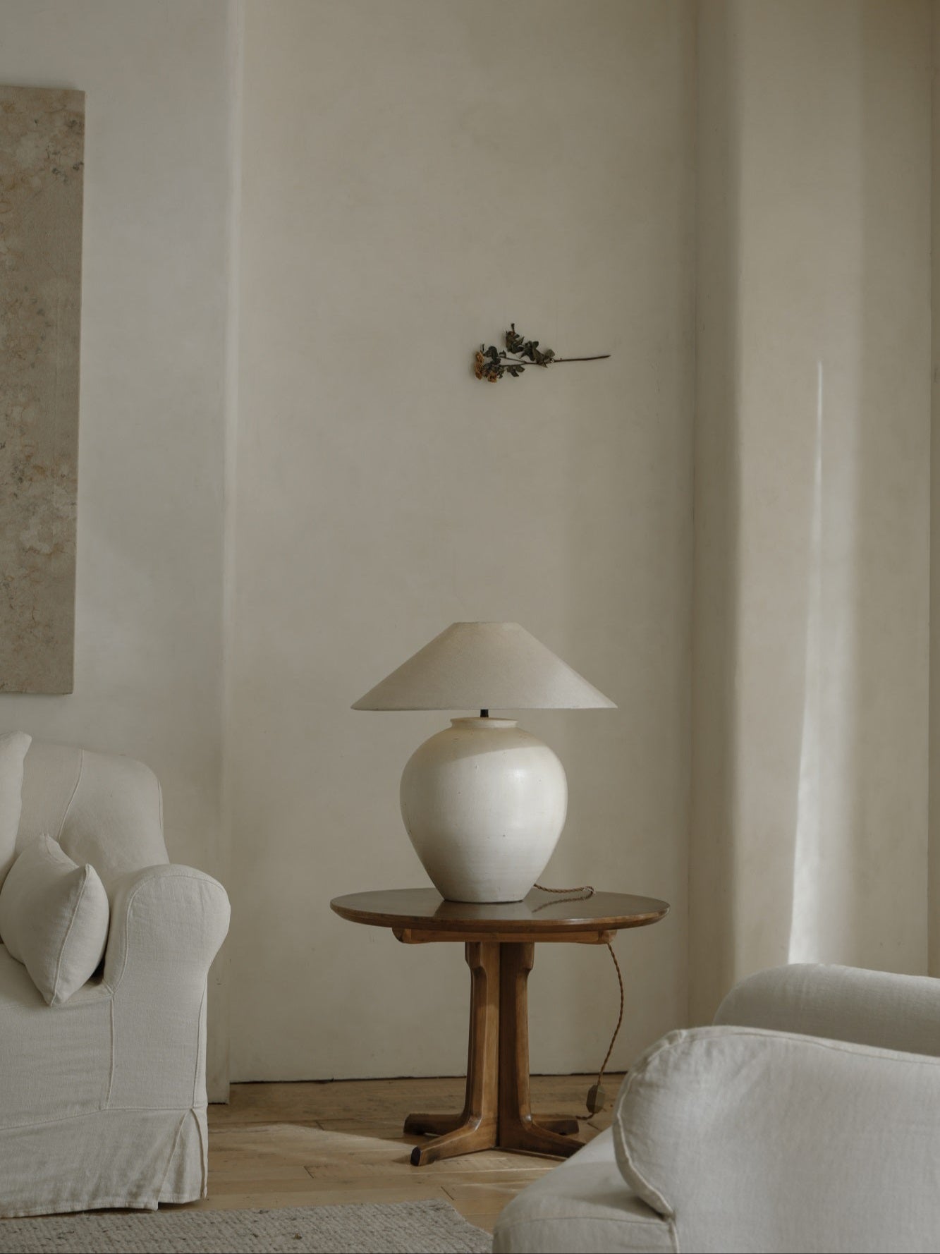 White clay Egg Lamp on a wooden table beside a white sofa, interior decor