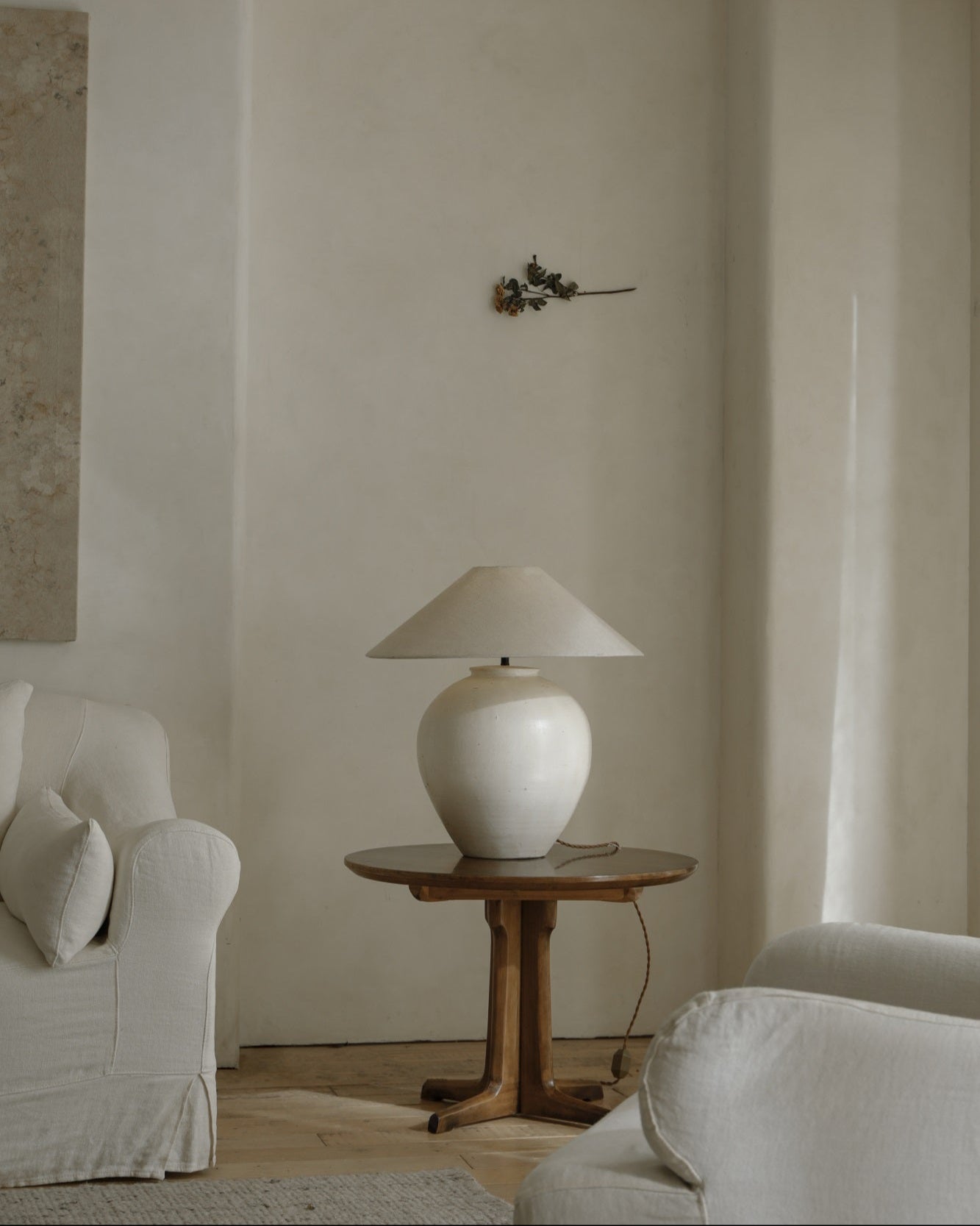 White clay Egg Lamp on a wooden table beside a white sofa, interior decor