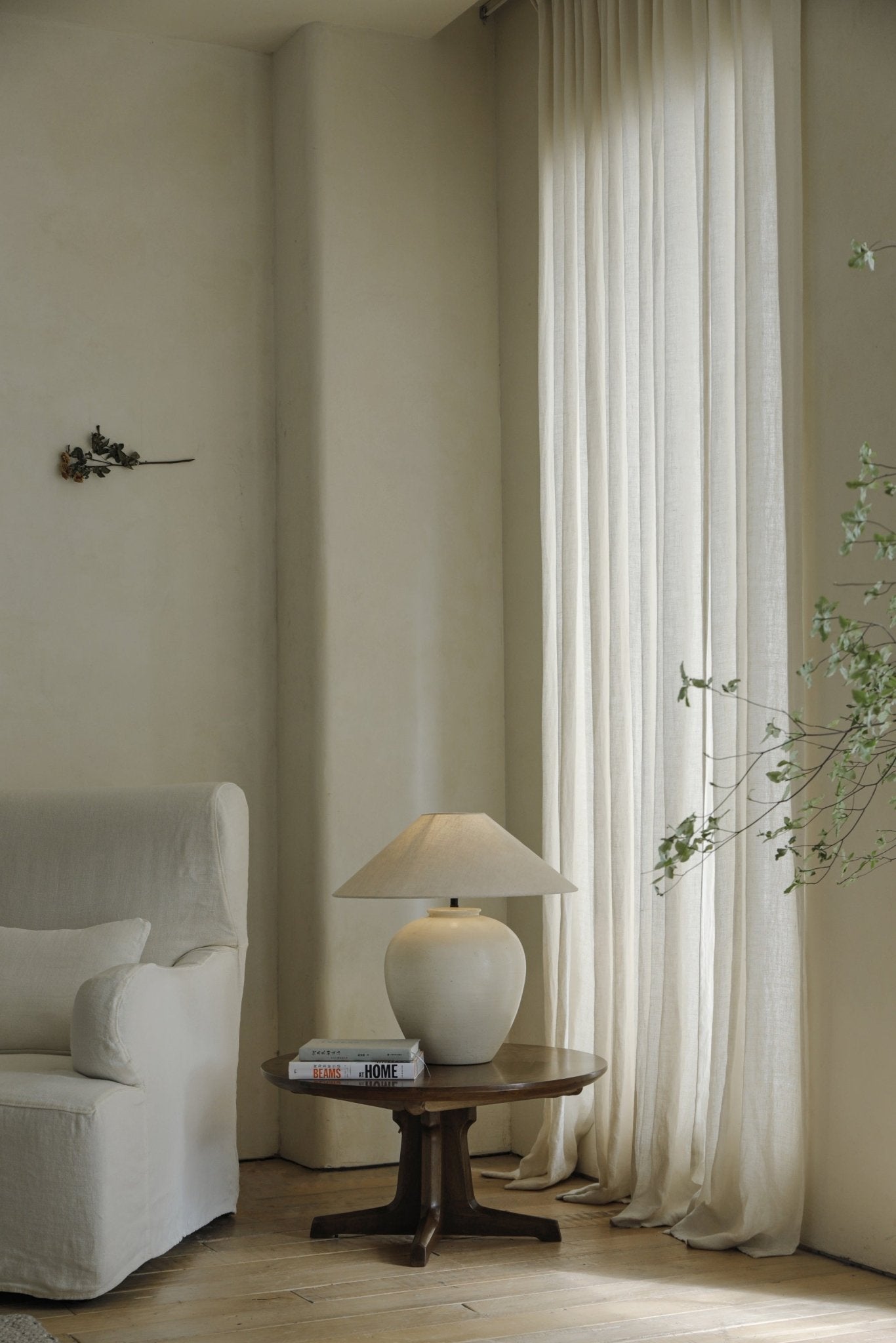 Egg Lamp on wooden side table next to white sofa, modern interior decor, clay material, BEAMS AT HOME books