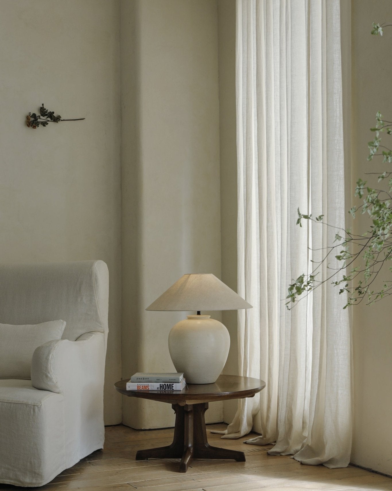 Egg Lamp on wooden side table next to white sofa, modern interior decor, clay material, BEAMS AT HOME books