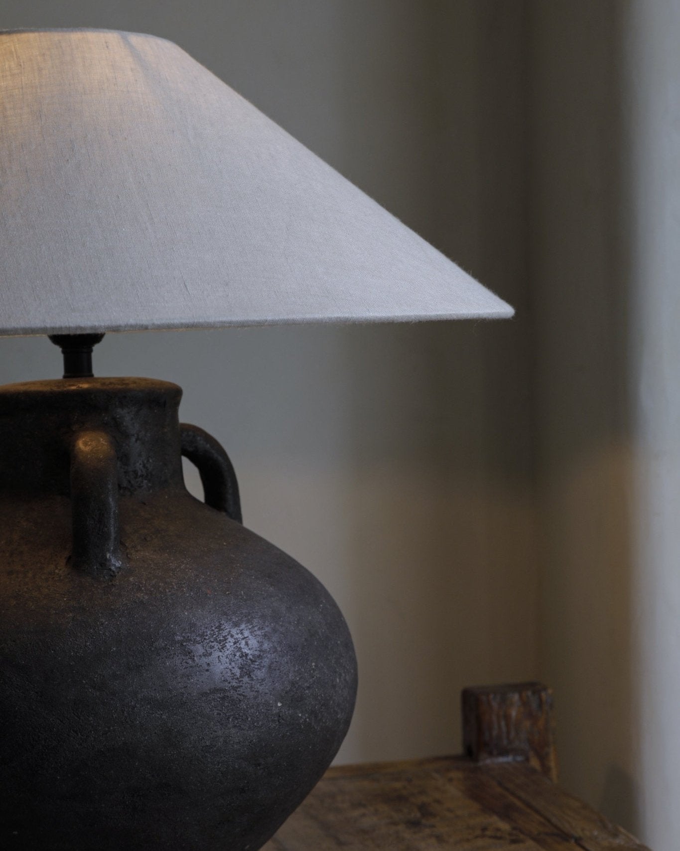 Ear Lamp with a textured dark clay base and off-white shade, providing soft lighting for home decor.