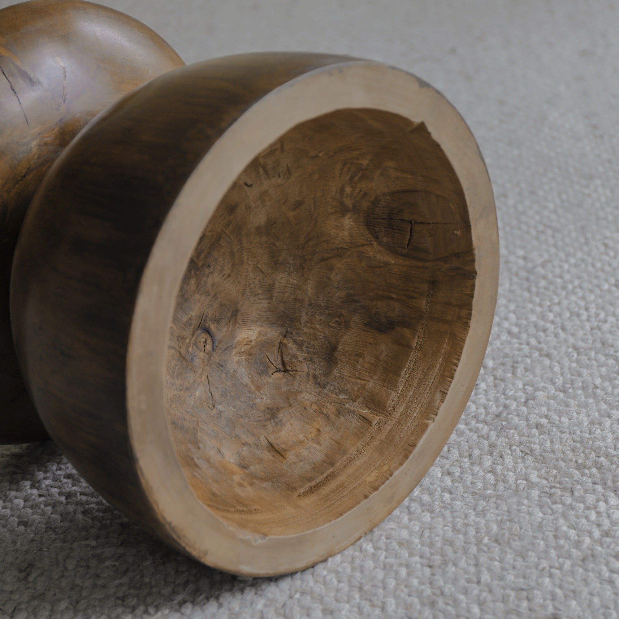 Close-up of a Sandglass Table made of Samanea saman wood, showing natural wood grain and texture.