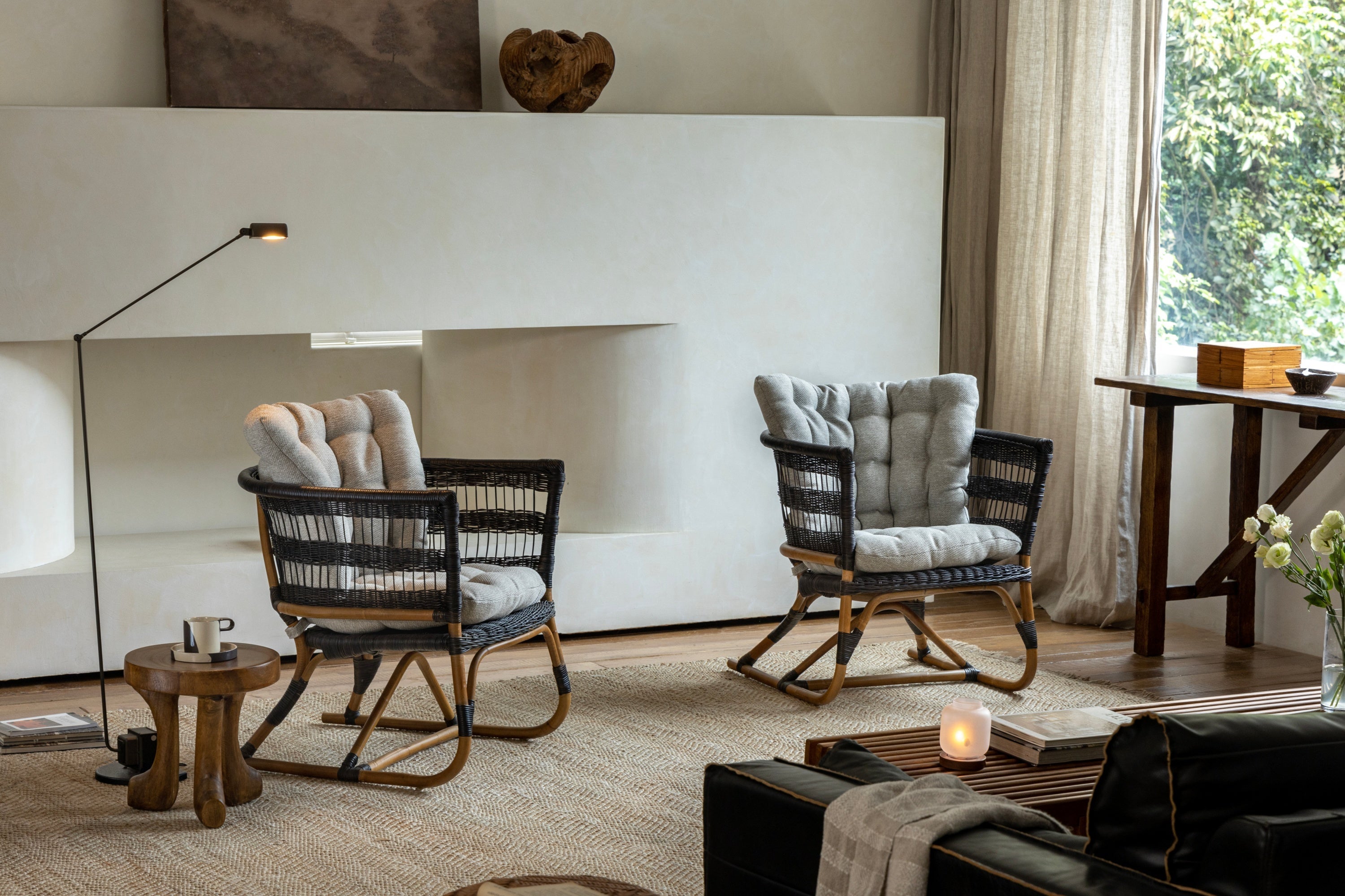 Two cushioned rocking chairs positioned near a minimalist fireplace in a cozy living room.