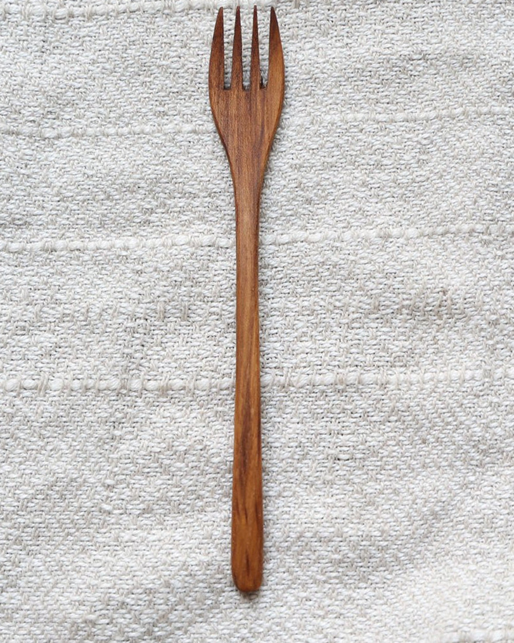 Single wooden fork, natural wood grain, perfect for eating. Part of the MIN JI product line, eco-friendly cutlery.