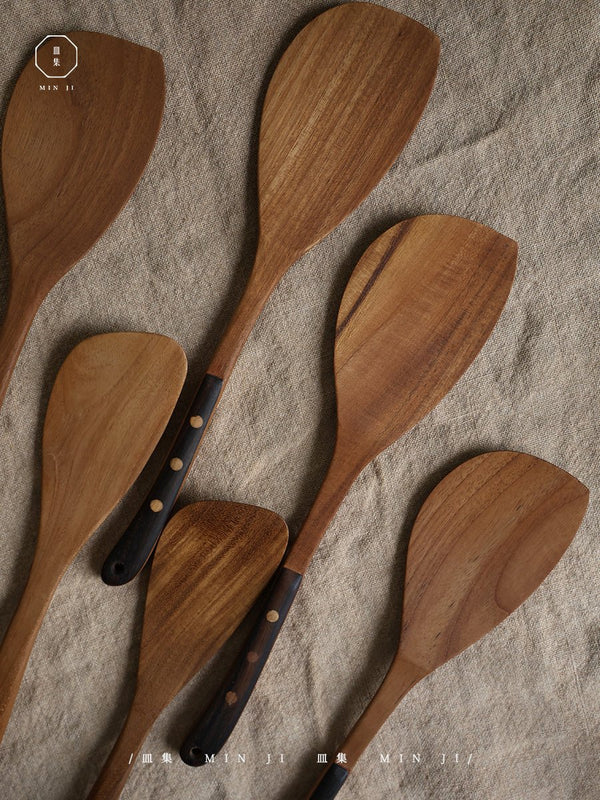 Set of wooden fried spatulas on natural linen fabric.