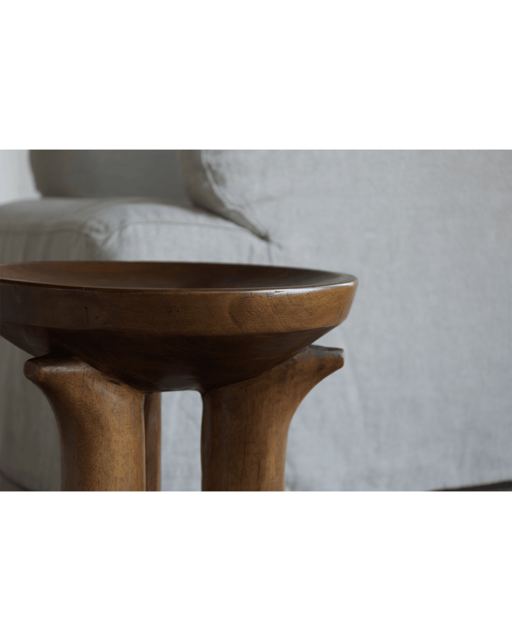 Quincy stool with a round top and curved legs in a minimalist living room.