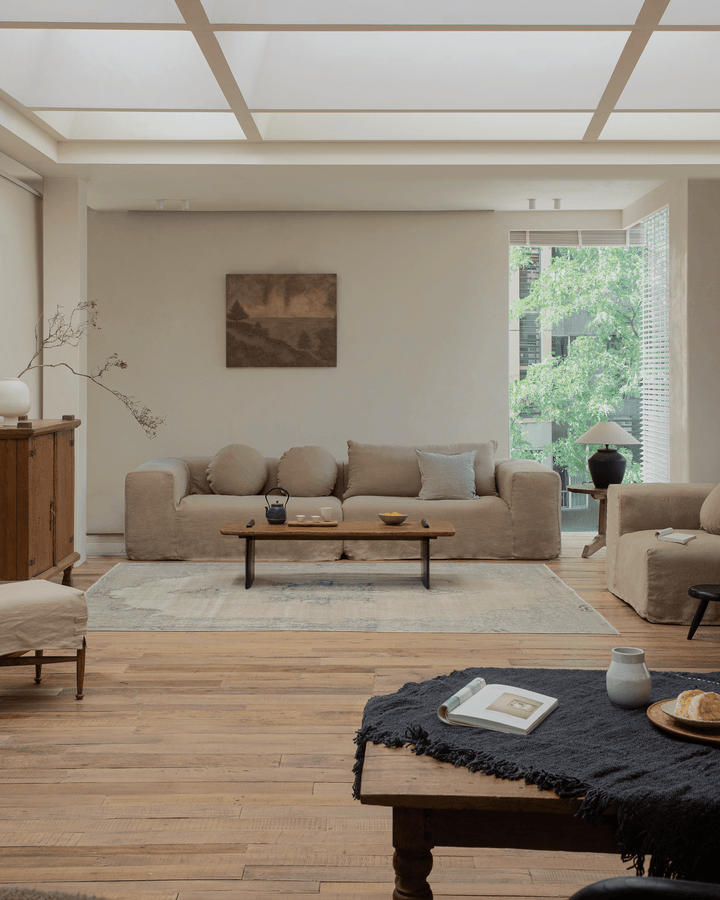 Beige Doma sectional sofa in a serene living room with a wooden coffee table and natural lighting.