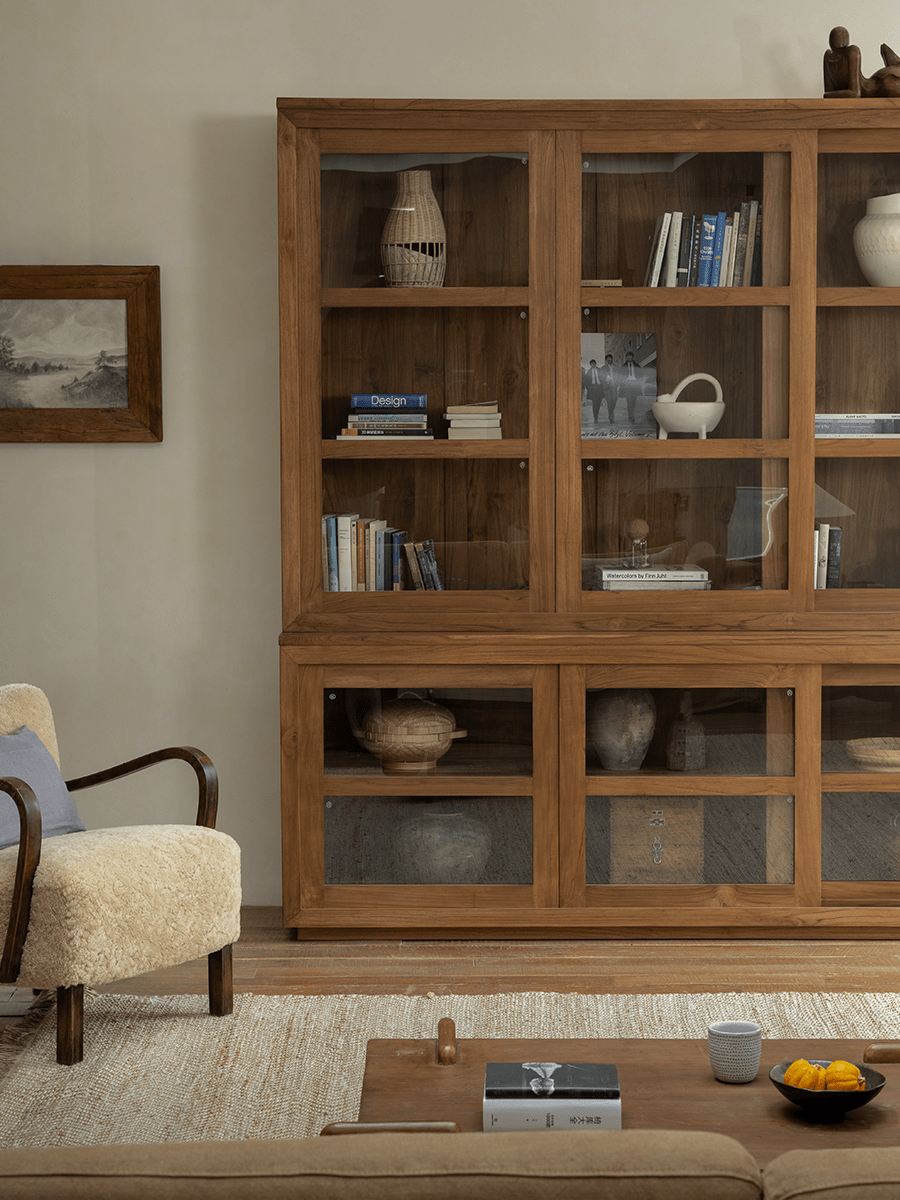 Teak wood glass front bookcase in a stylish living room, perfect for display and storage.