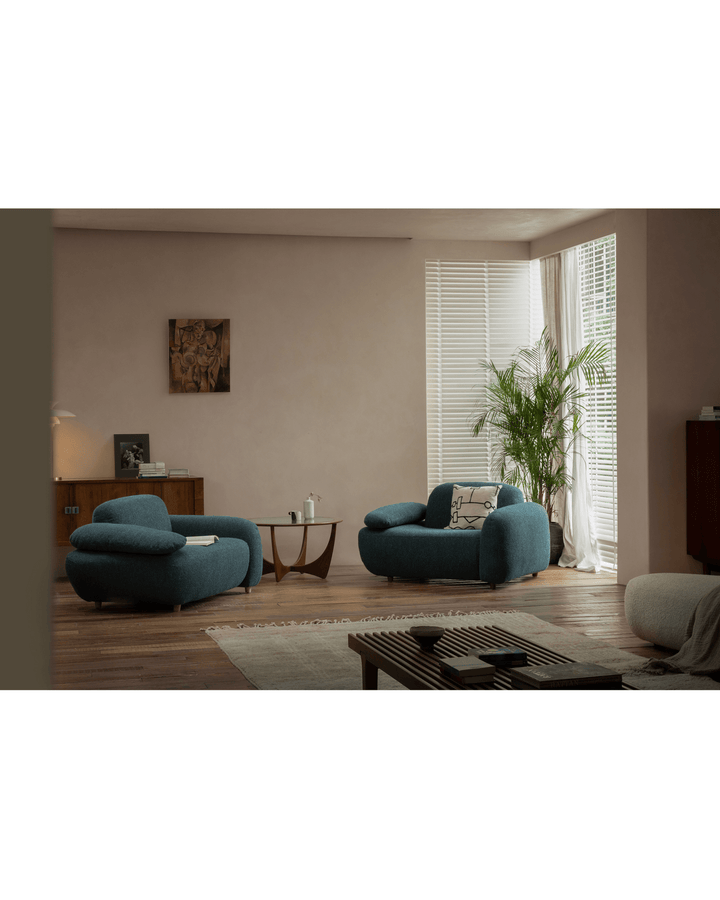 Teal Gestein Bouclé Armchair in a stylish living room with plants and coffee table.
