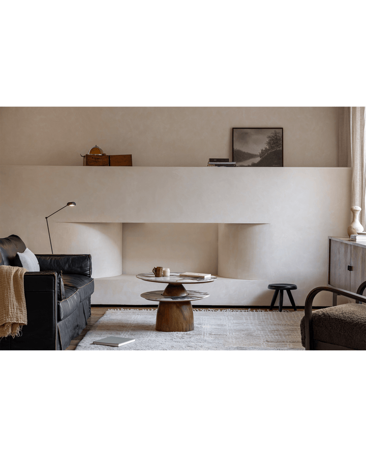 Elegant round side table with crystal top and wooden base in modern living room setting.