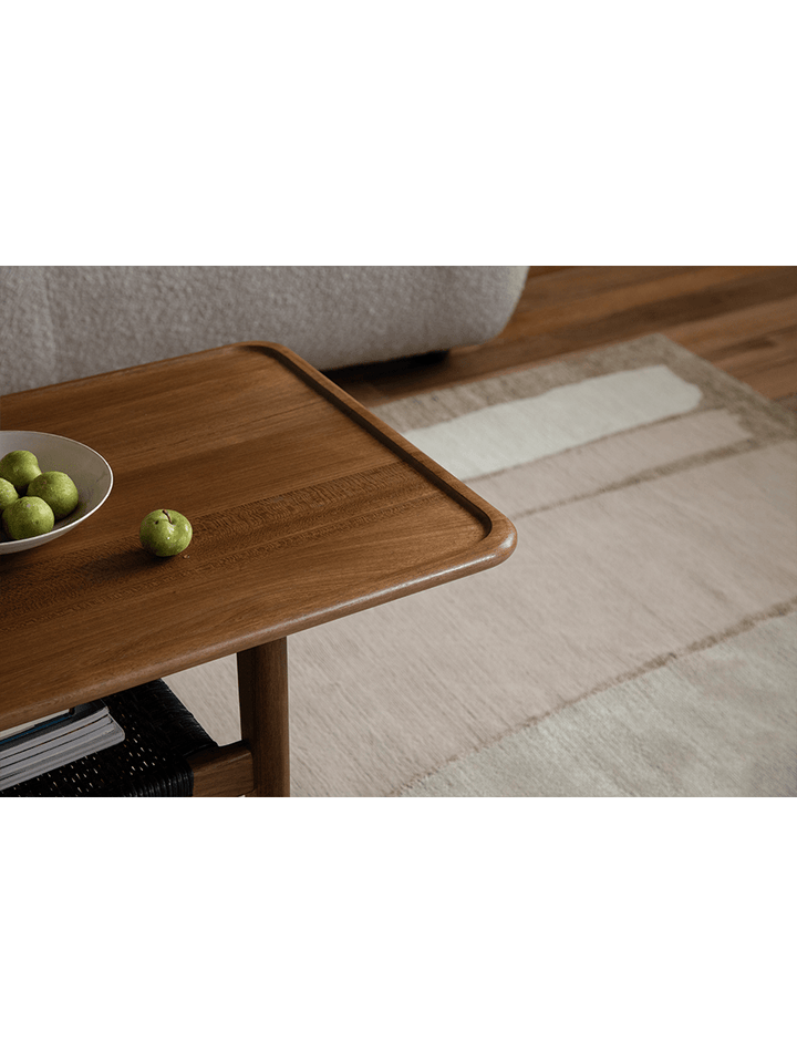 Close-up of wooden accent table with green apples in a modern living room.