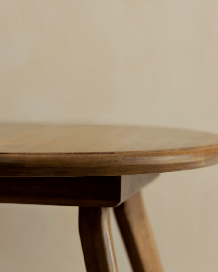 Close-up of Ele Round Side Table highlighting smooth wooden top and curved legs.
