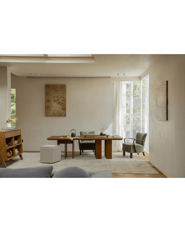 Spacious wooden dining table with chairs and decor in bright interior.