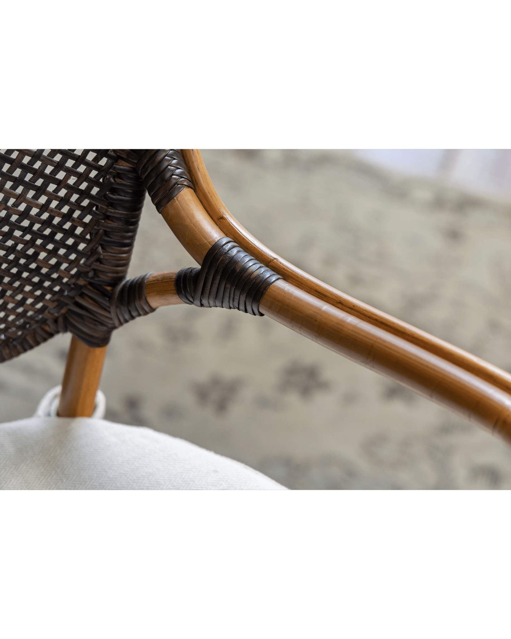 Close-up of Areca Rattan Chair detailing handwoven backrest and armrest connection, natural comfort design