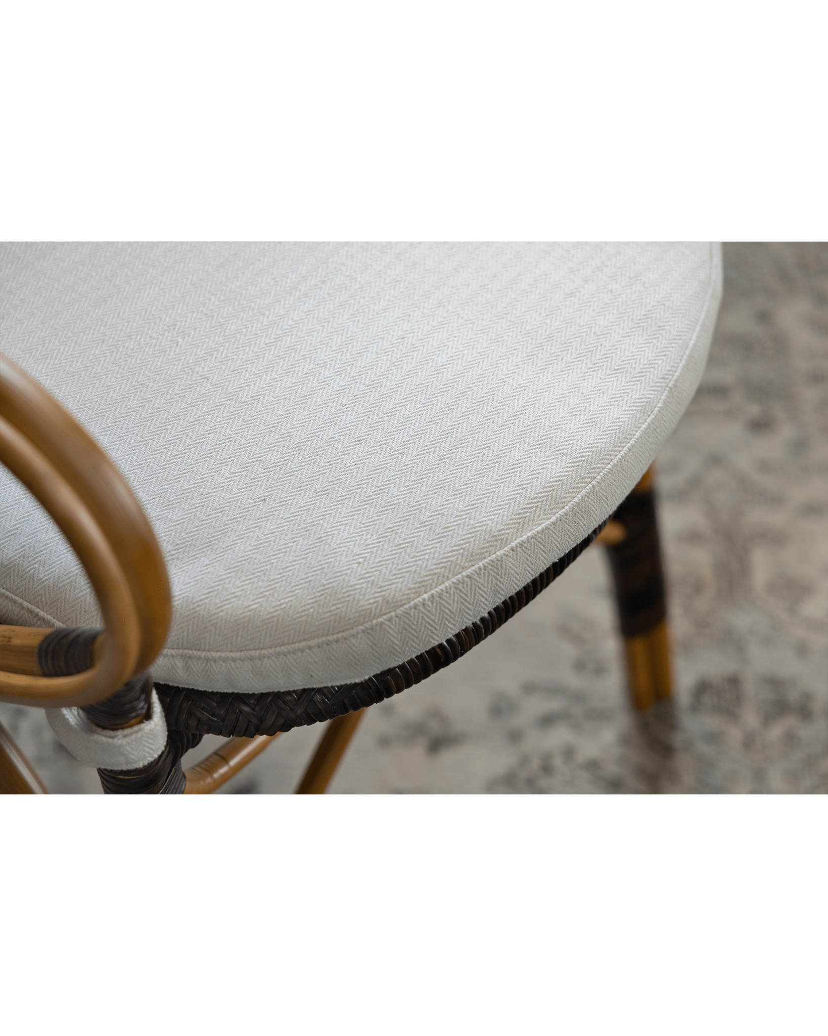 Areca Rattan Chair, close-up of white cushion with herringbone pattern, natural rattan frame, and armrest detail