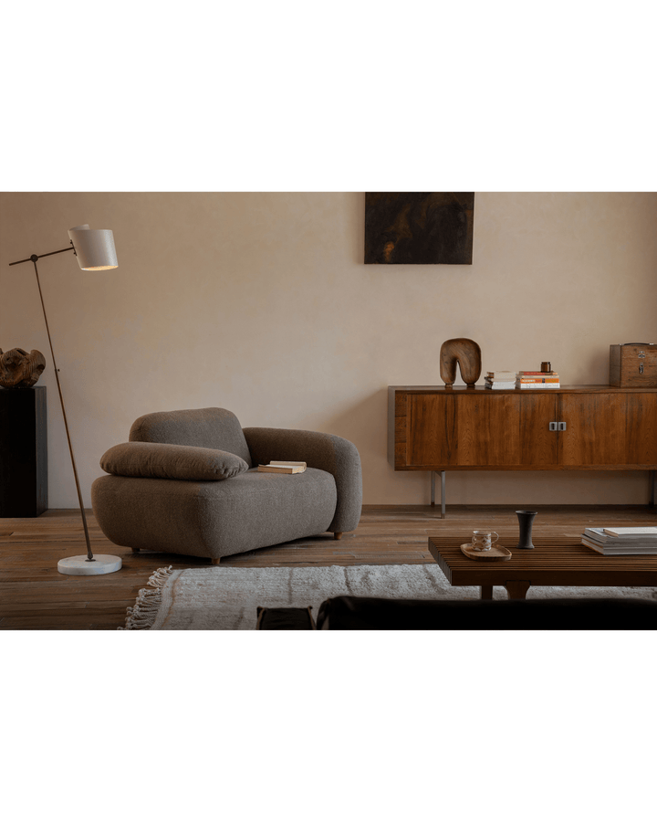 Cozy brown Gestein Bouclé Armchair in modern living room with wooden cabinet.
