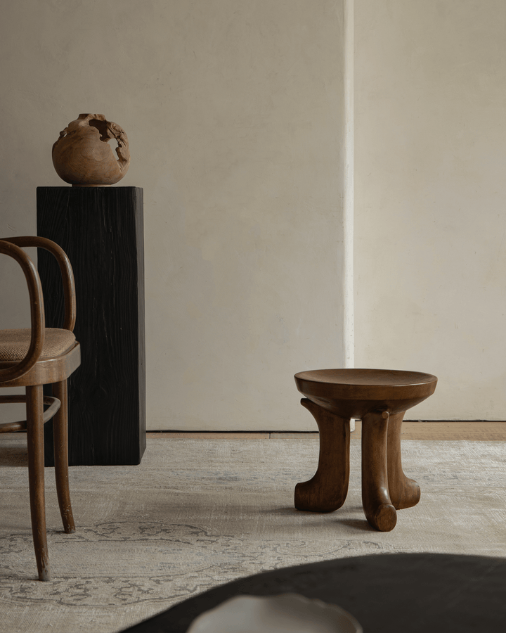 Handcrafted Quincy stool in an elegant, serene living room with sculptural decor.