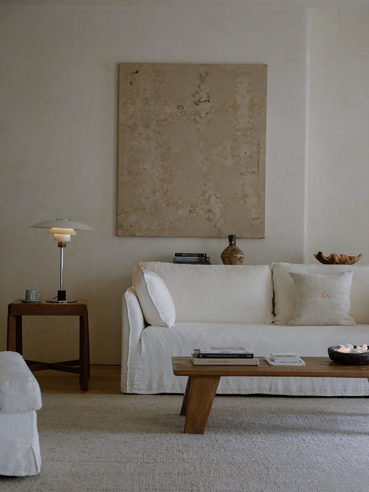 Elegant living room with a white sofa, wooden coffee table, and stylish home decor.