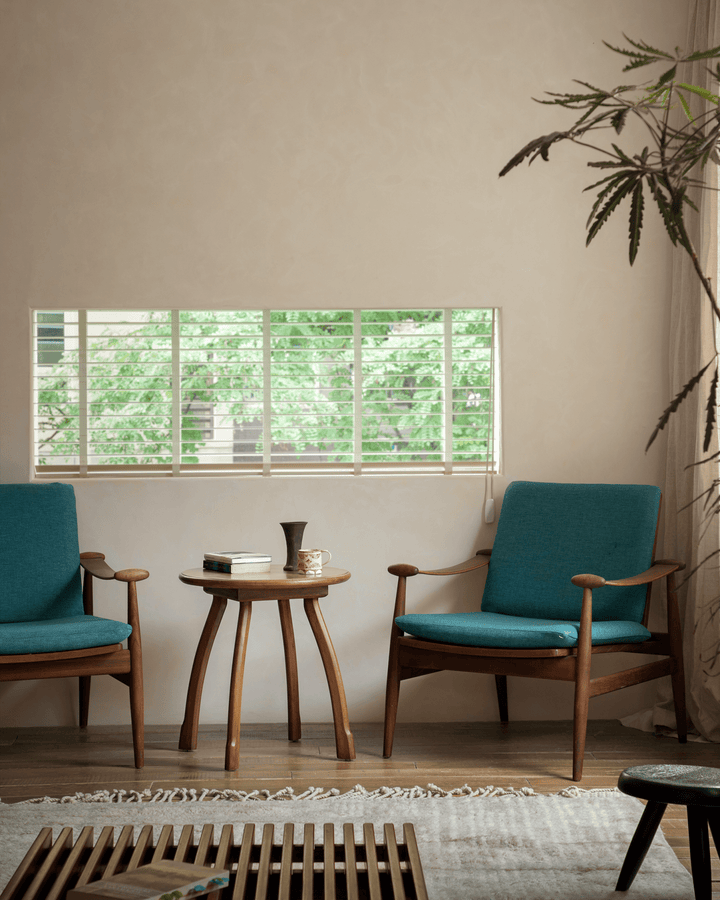 Ele Round Side Table in a cozy living room with teal chairs and a bright window view.