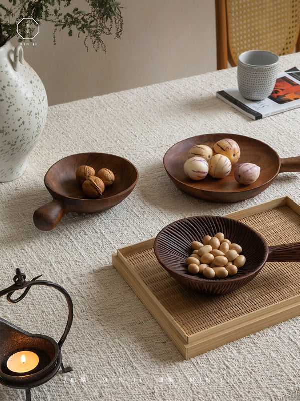 Wooden bowls with snacks on a dining table, showcasing a modern vintage style.