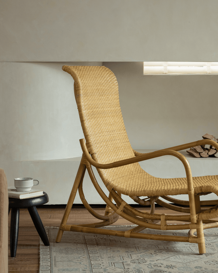 Nalgae rattan lounge chair with curved backrest in a minimalist living room.