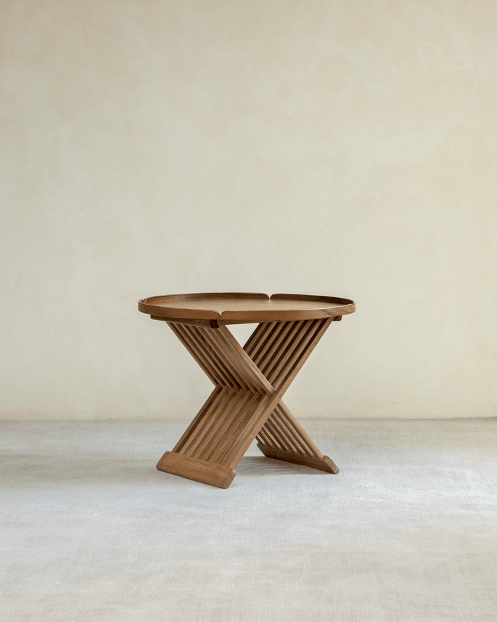 Folding coffee table with a unique slatted design in a minimalist setting.