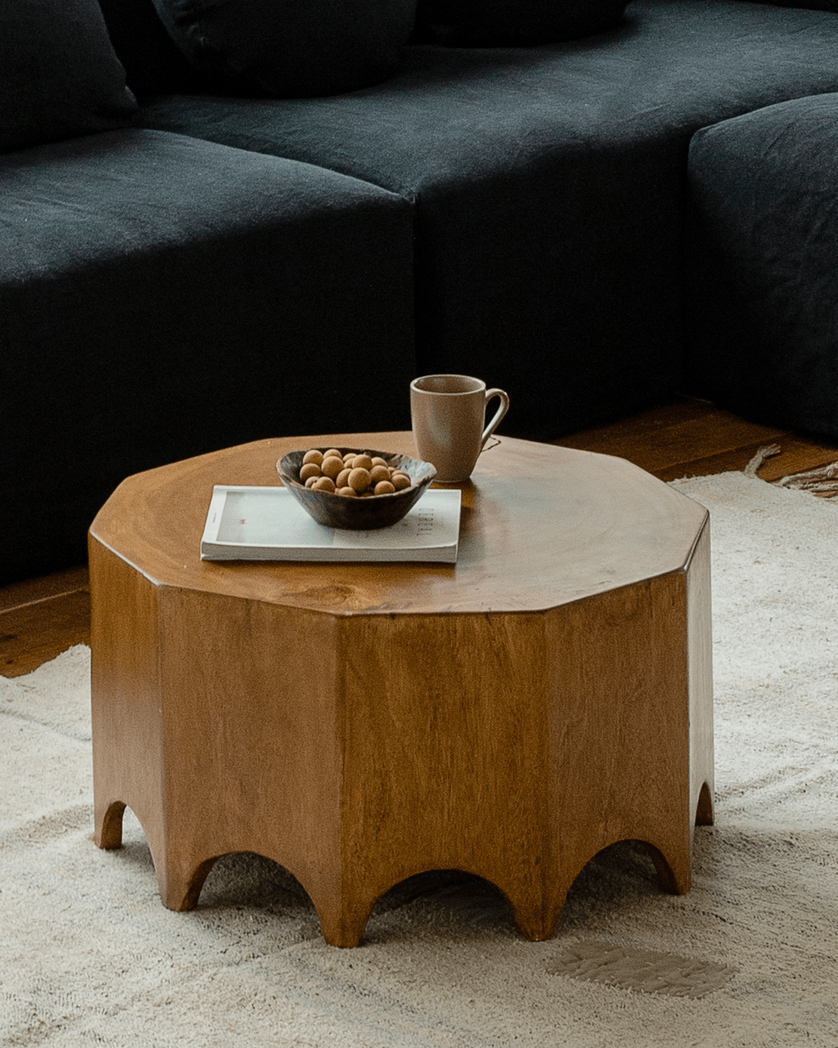 Decagon Side Table in solid rainwood, ten-sided design, and light brown finish in a living room setting.