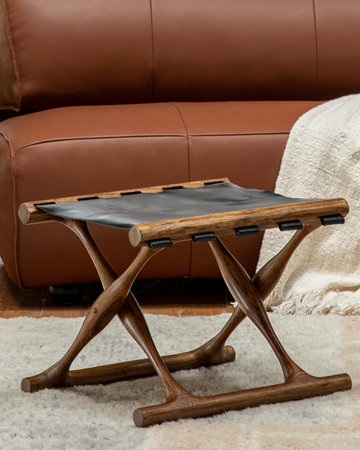 Teak folding stool with black saddle leather seat and X-shaped legs