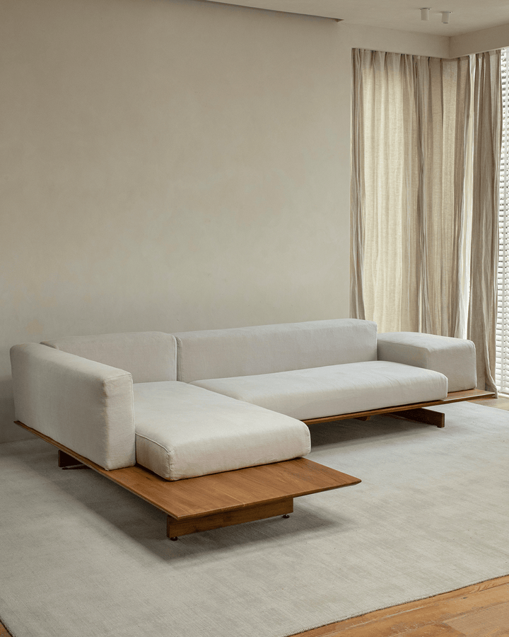 Modern linen modular sofa with teak base in a minimalist living room