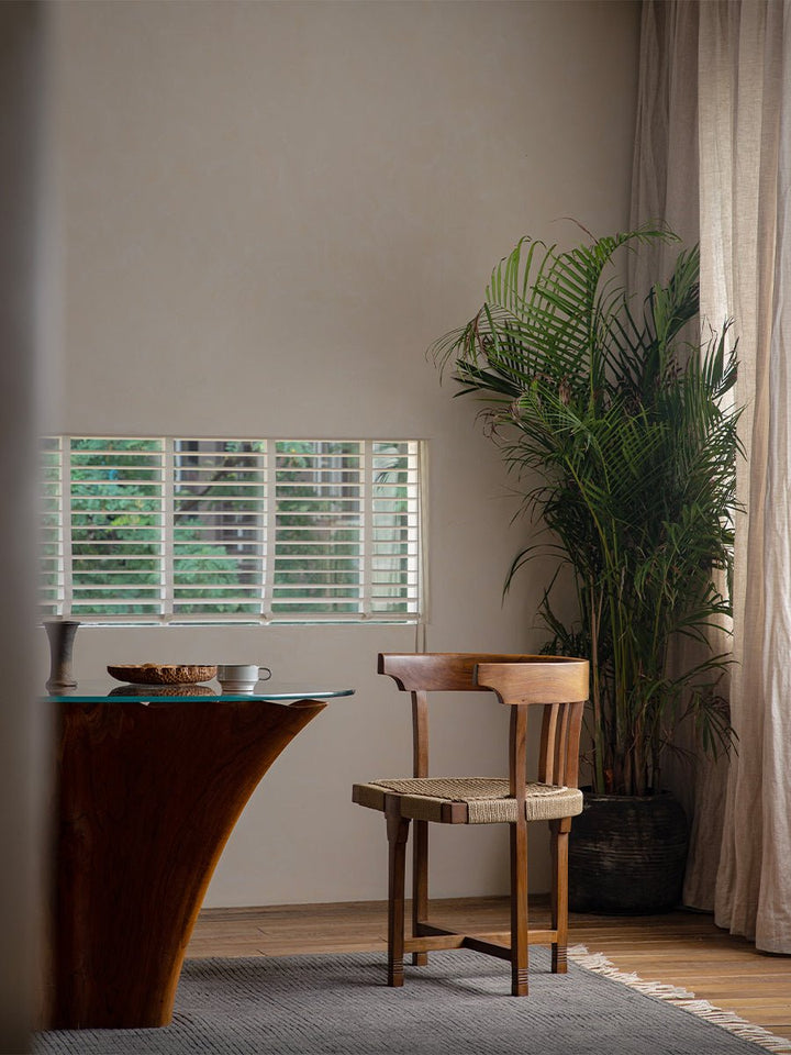 Stylish wooden dining chair beside a table in a light-filled indoor space
