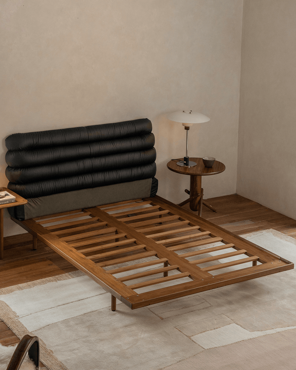 Teak bed frame with black leather backrest in contemporary bedroom