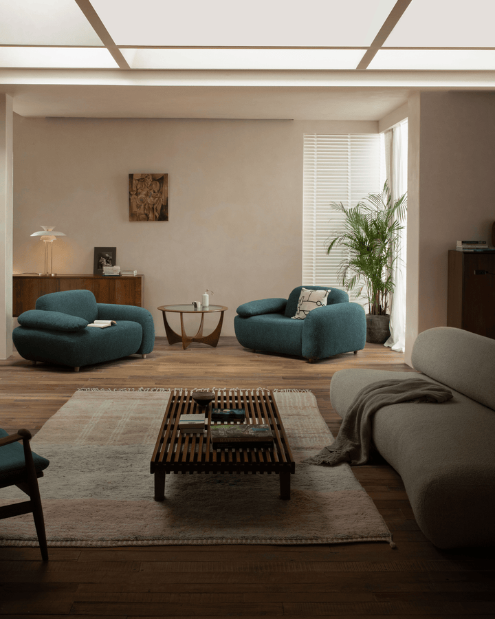 Teal Gestein Bouclé Armchair in a cozy living room with warm decor and indoor plants.