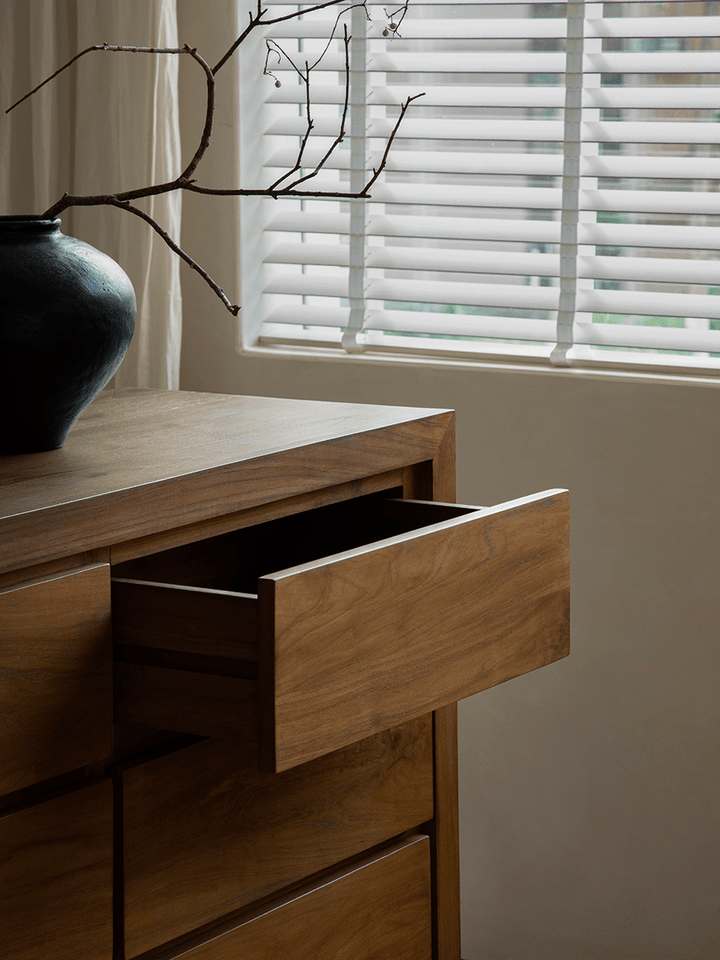Open drawer of Palette Teak Sideboard with black vase in modern living room.