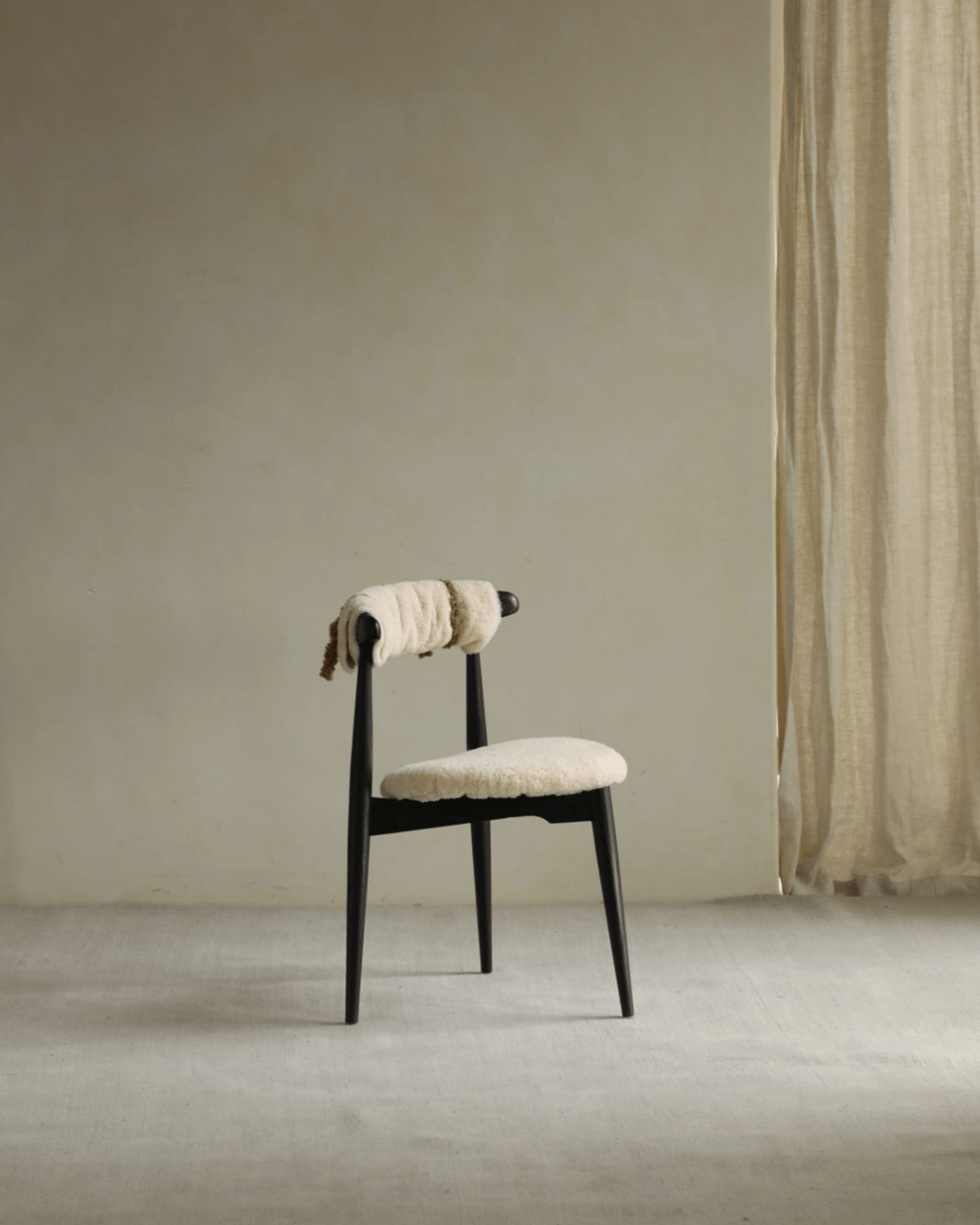 Heart Dining Chair with shearling upholstery and black frame in a vintage interior decor, Danish design