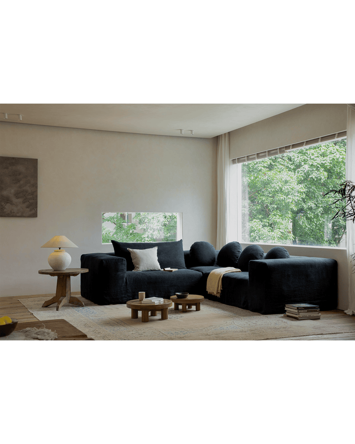 Miya Coffee Table Sets in a modern living room featuring a black sofa and large window.